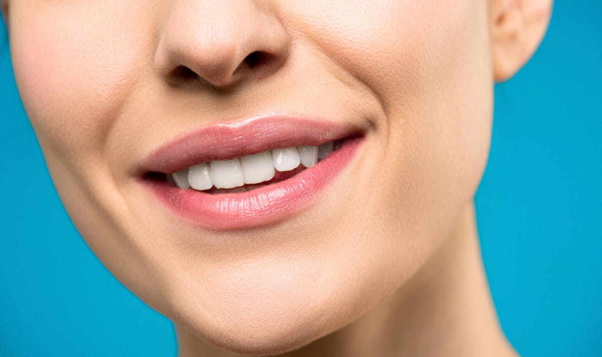Femme souriante mettant en valeur des dents saines et lumineuses