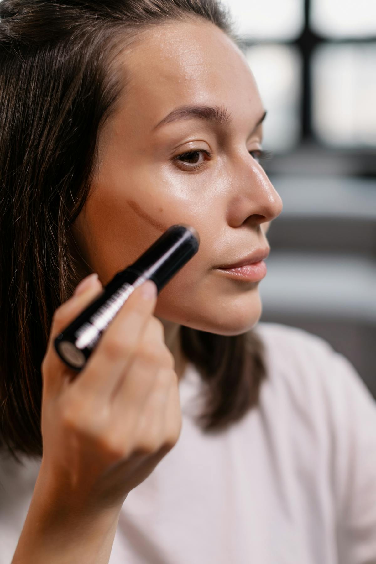 Application d'un produit de contouring sur les pommettes au pinceau