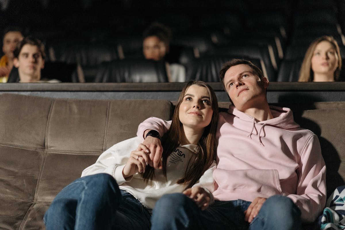 Couple regardant un film d'amour blotti sous un plaid