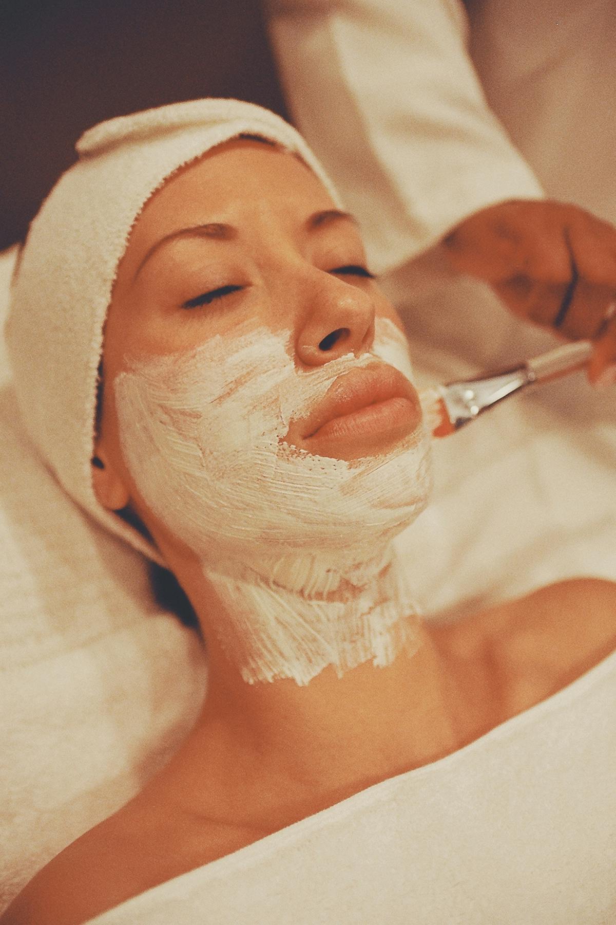 Femme recevant un soin raffermissant du visage en institut