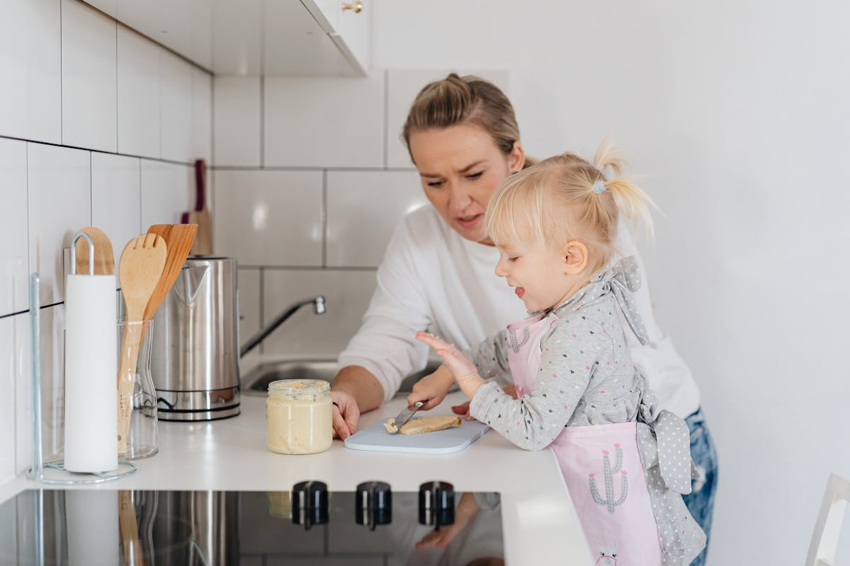 Jeune enfant sur une tour Montessori participant en cuisine