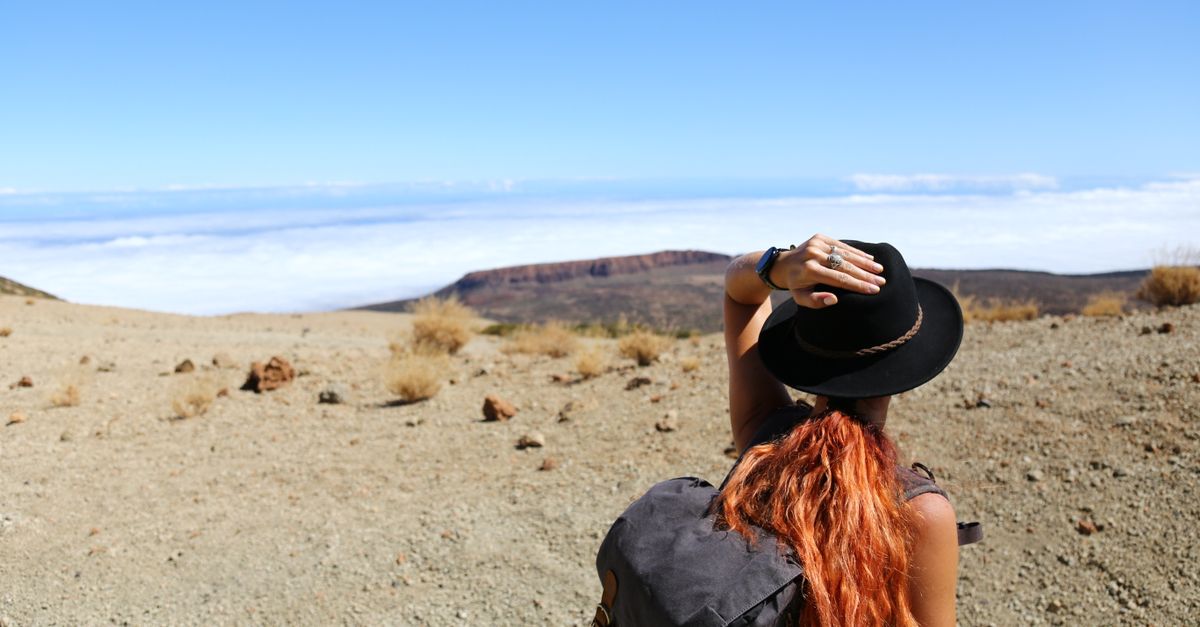 Femme avec sac à dos en voyage solo dans un paysage naturel