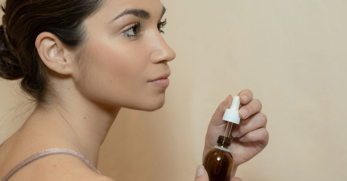Flacon de sérum naturel à l'huile posé sur une table en bois clair